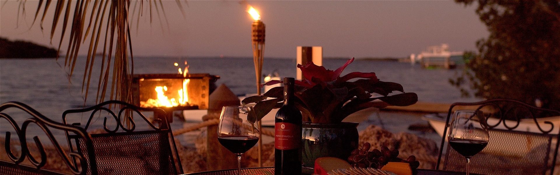 BBQ grill and dinner table set at sunset, overlooking the bay.