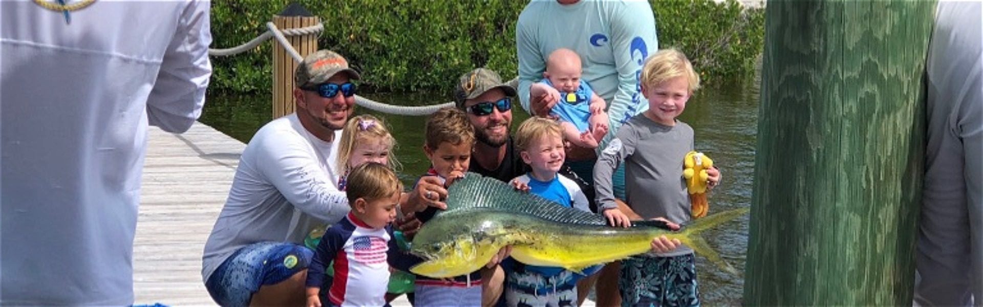 Family group of parents and kids showing off their catch of the day