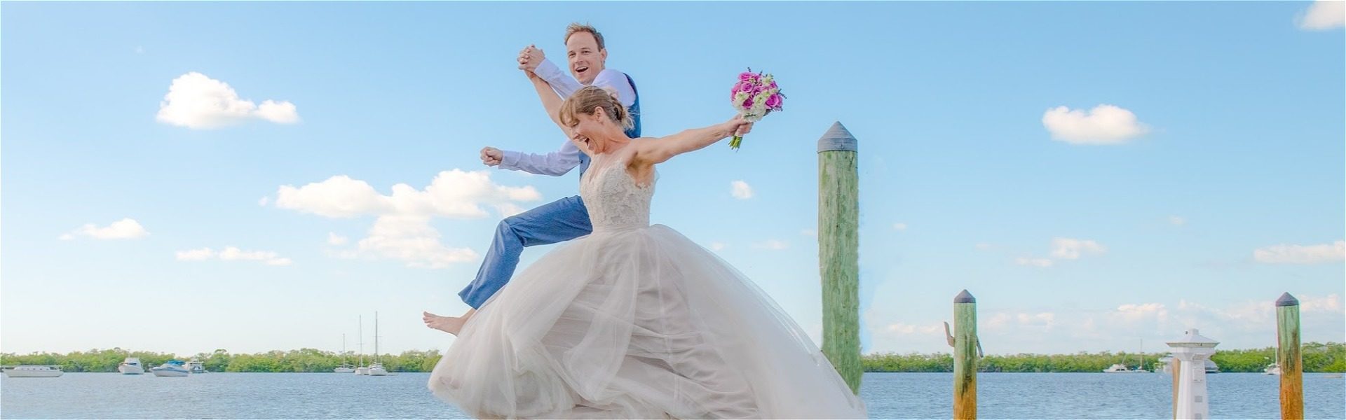 Happy couple taking a leap from the dock at the coconut palm inn